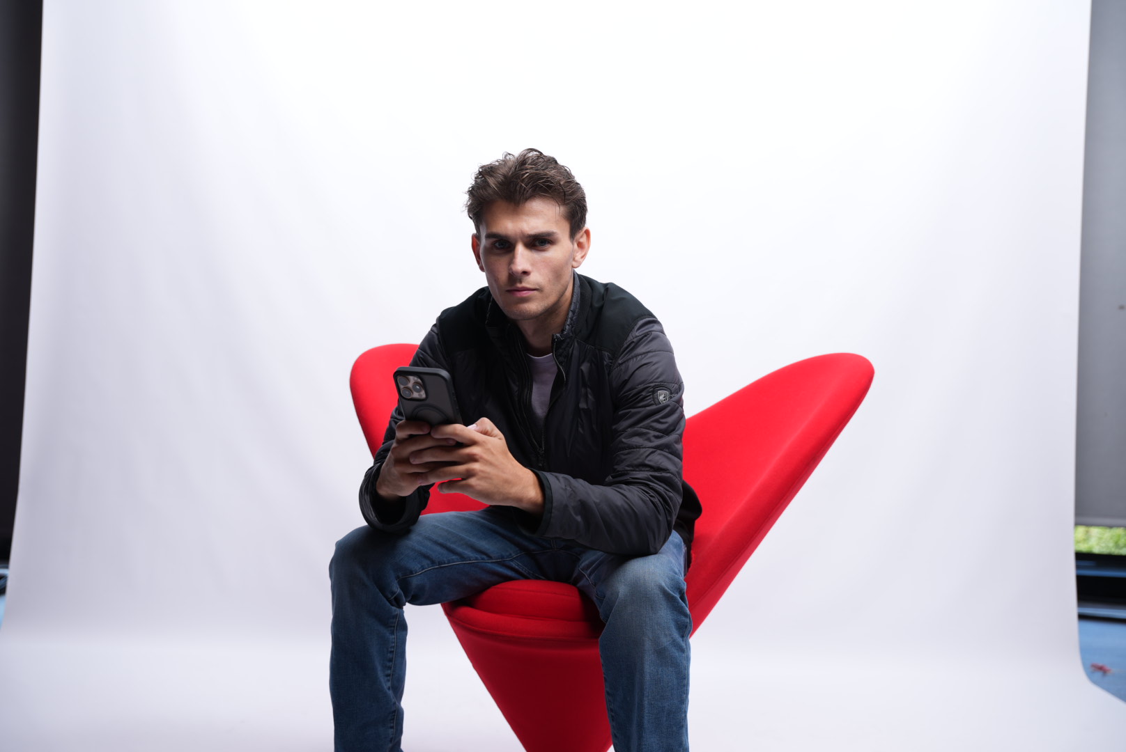 Utah Sicsko leaning forward in a red studio chair